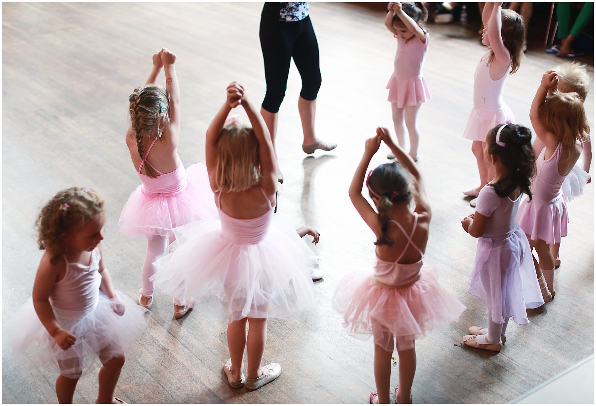 Pre-school dancers in pink tutus standing in a circle